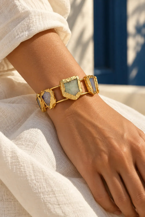 Aurelia Gold Five Stone Cuff Bracelet by ORIGEN, worn on a model, cream editorial hero